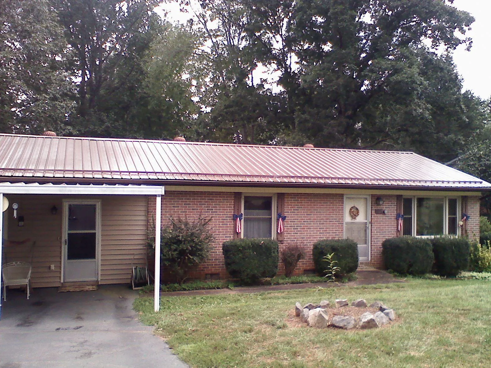 Bronze metal roof and carport on a brick ranch home — Roof Repair work by our crew in Bellevue